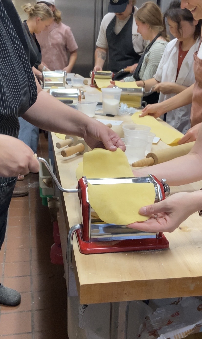 Neighbors making fresh pasta together at an OMI gathering