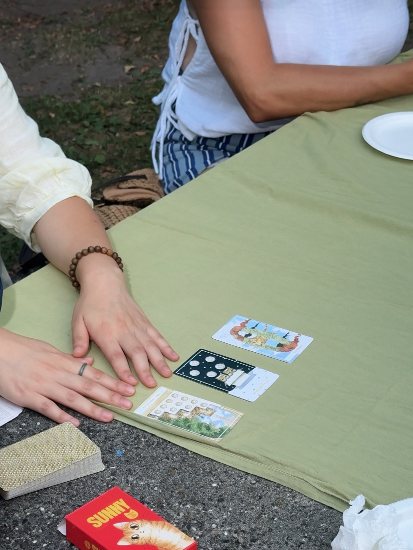 Guests sharing illustrated cards around a picnic table at an OMI event